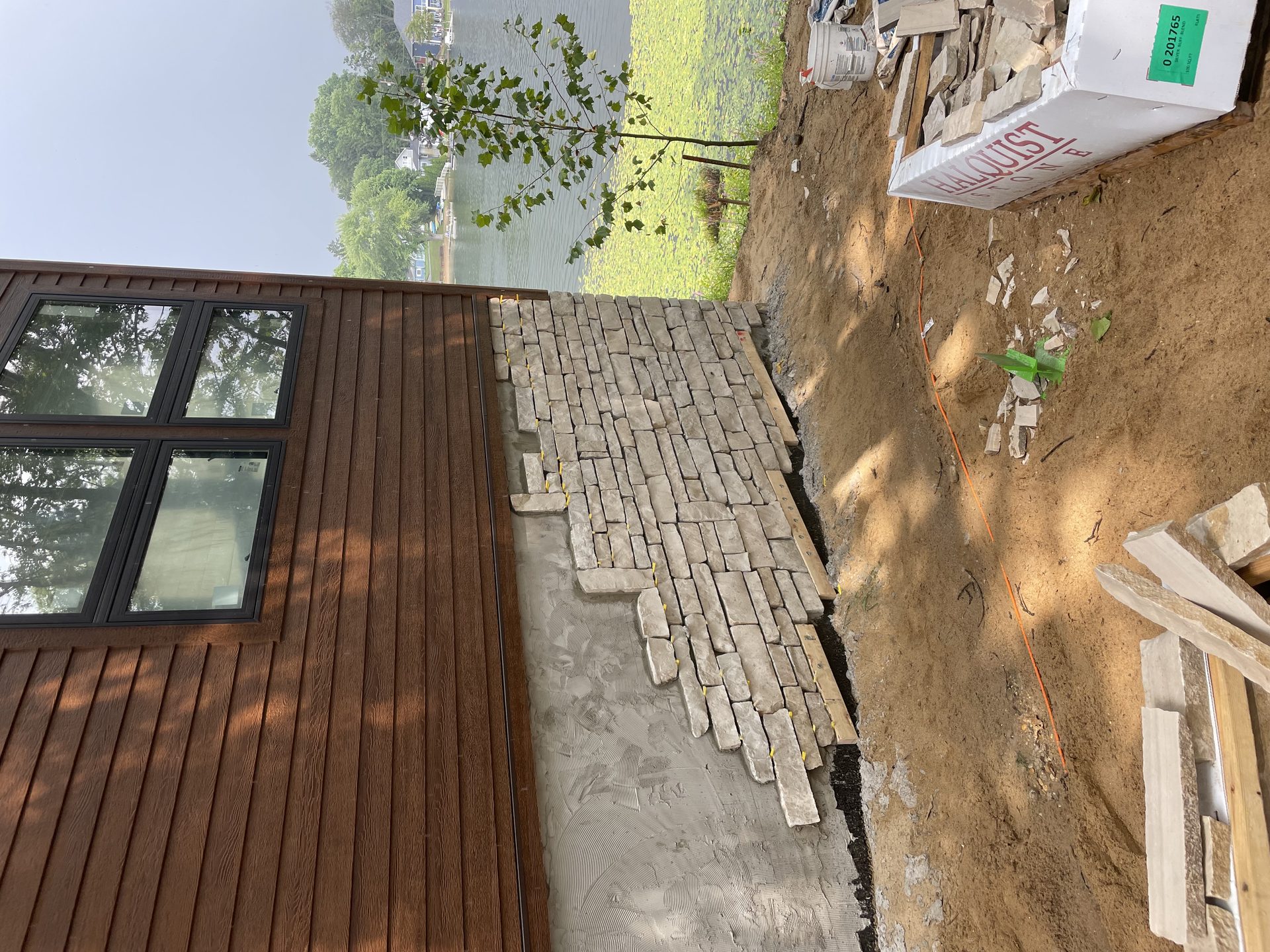 Natural stone retaining wall installation with lake view