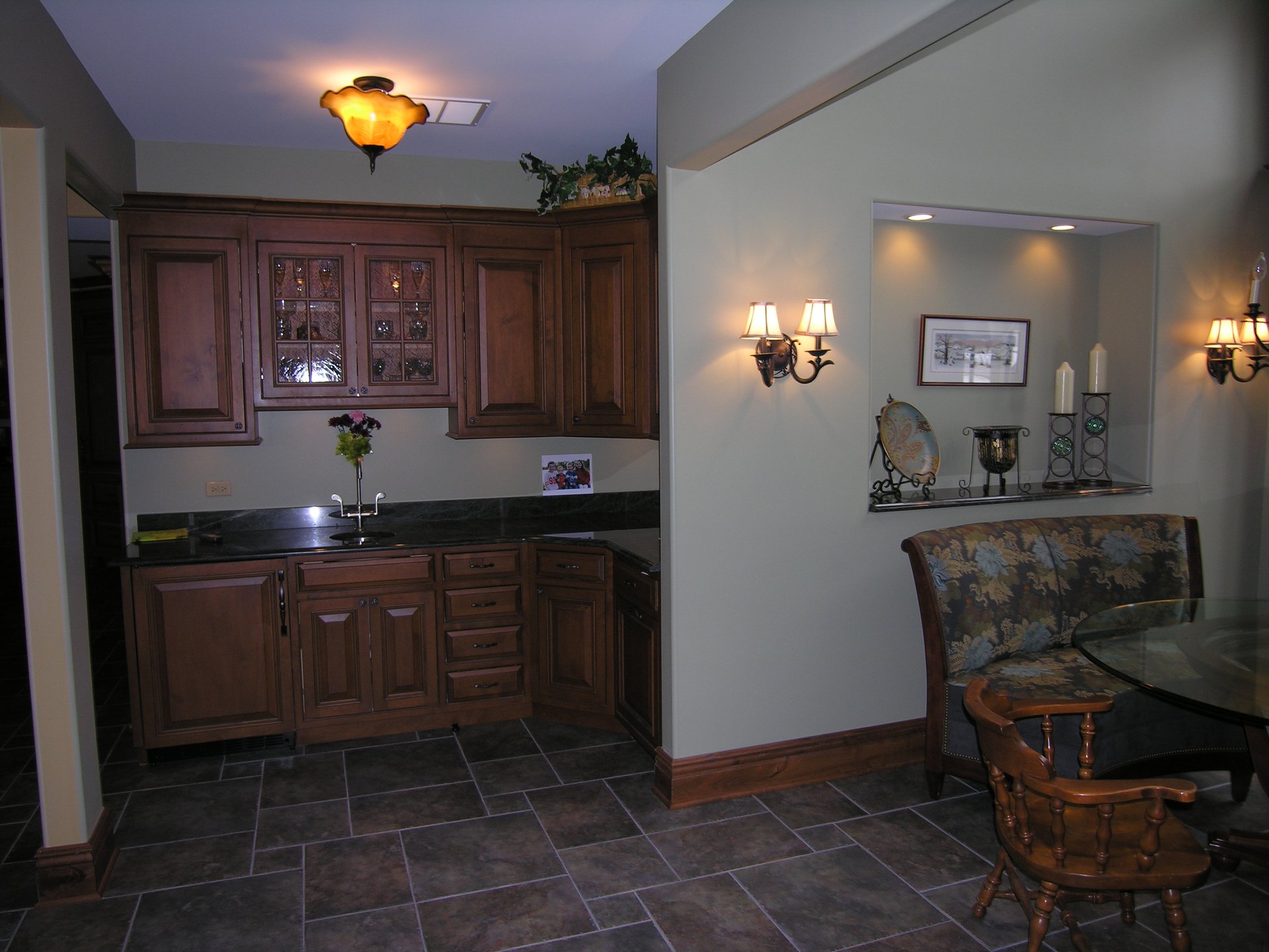 Custom wet bar with granite counter and glass-front cabinetry