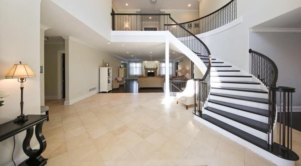 Custom curved staircase with wrought iron railing in a two-story foyer